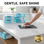 A person using a soft Kirkland Signature baby wipe to gently clean a smudge off a tablet screen on a white marble kitchen island.