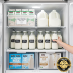 An organized large family refrigerator with Kirkland milk gallons and glass bottles placed on the cold back shelves for maximum freshness.
