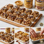 A wooden board displaying various homemade nut bars with chocolate drizzle, coconut flakes, and dried berries next to jars of Kirkland almond butter and mixed nuts.