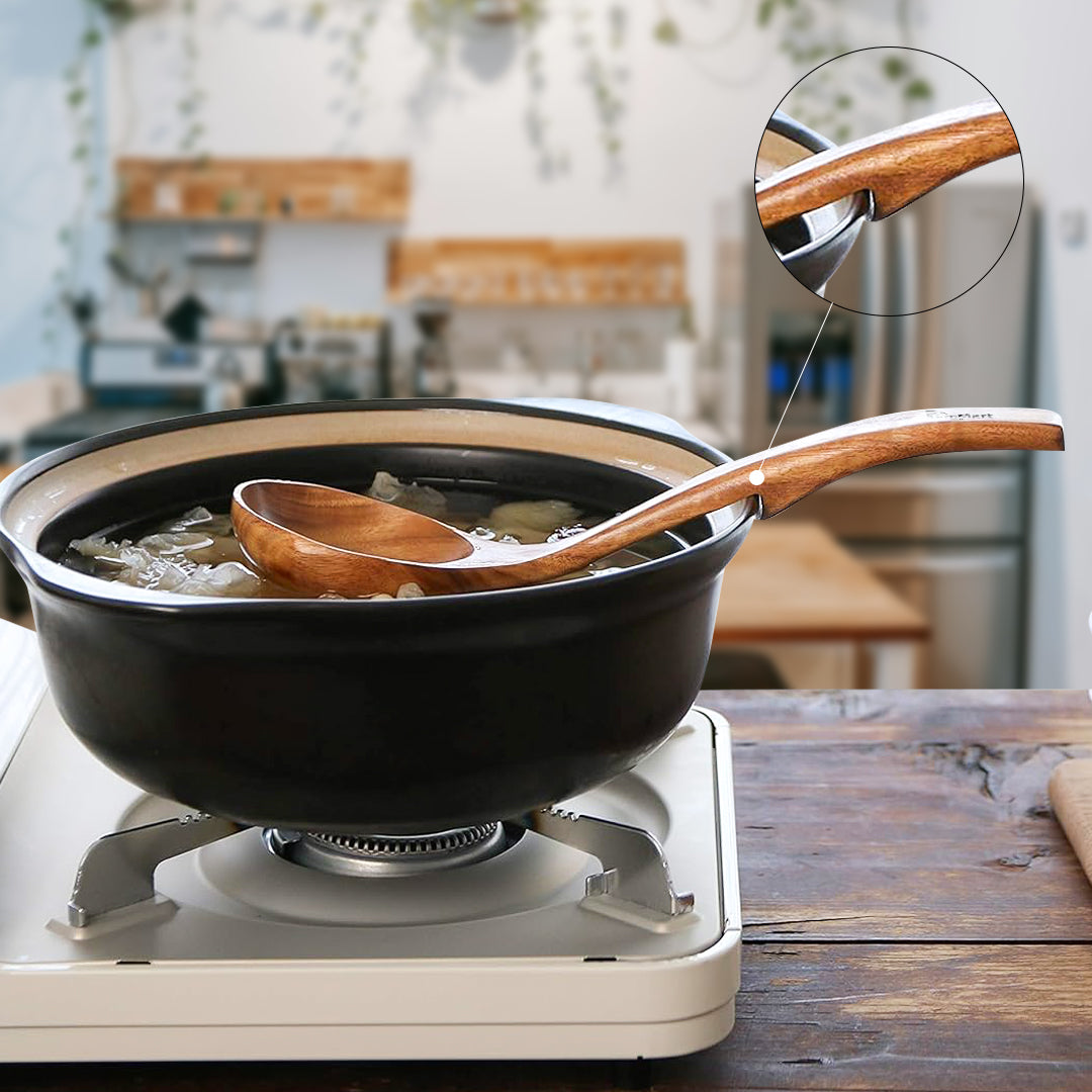 Black wok on a portable stove filled with water and ice, with a wooden ladle resting on the rim, shown in a kitchen background.